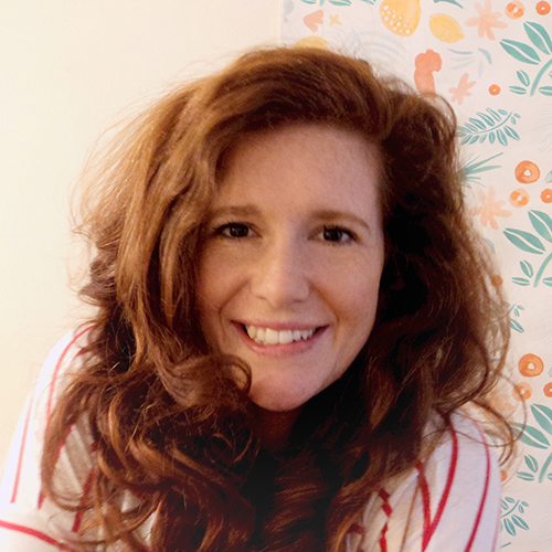 A lady with red hair smiling at the camera
