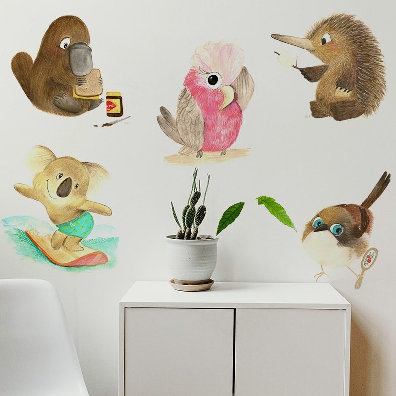 An example image showing some of our Native Animals Wall stickers on a wall above a cupboard and a chair. On this wall is five decals, each a native animal to Australia. This image includes: Ken the Koala Gail the Galah Sam the Scrubtit Paul the Platypus Karl the Kangaroo Ed the Echidna