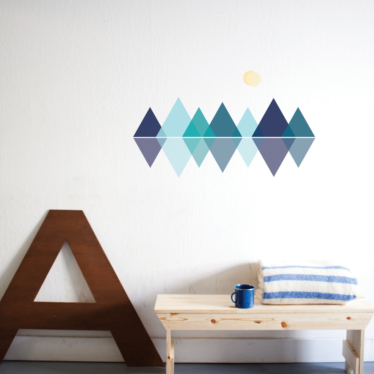 Paige Russell Mountain Range removable wall stickers behind a table with towel and mug on top