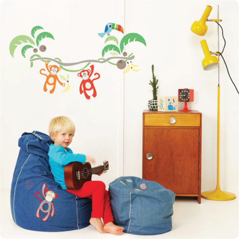 Jungle Canopy Removable Wall stickers with a boy in front sitting on a bean bag while playing a guitar