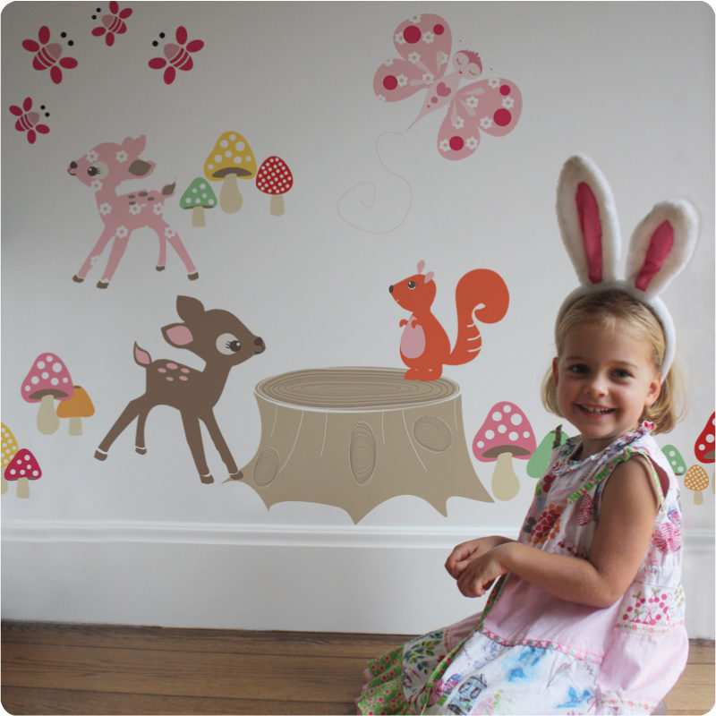 Enchanted Wood removable wall stickers by Cocoon Couture with a smiling girl sitting infront