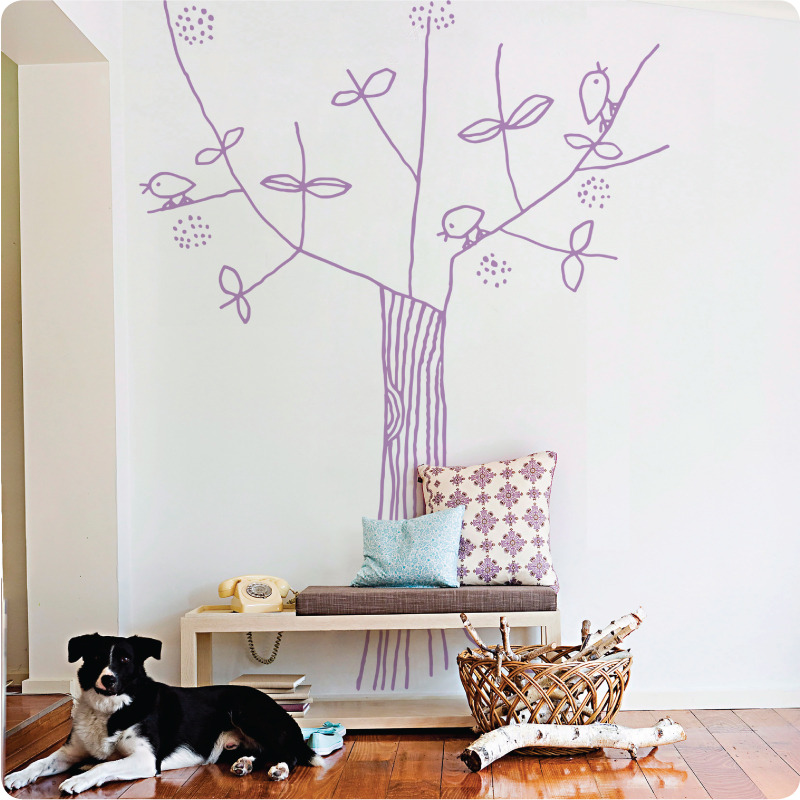 Tree and Bird removable wall stickers by Jane Reiseger a cabinet with telephone and pillows on top
