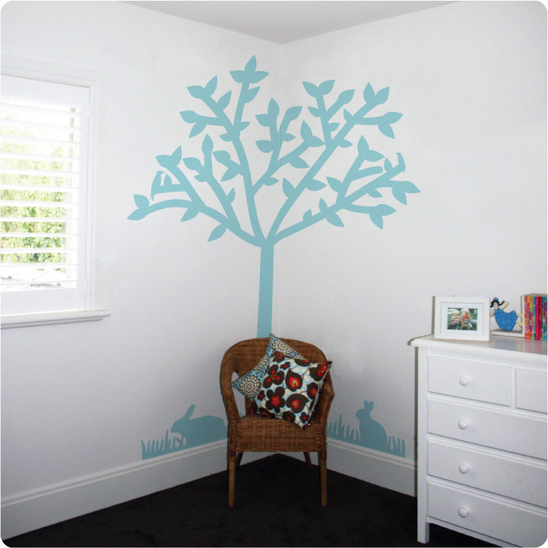 Tree silhouette removable wall sticker with pillow in front on top of the chair