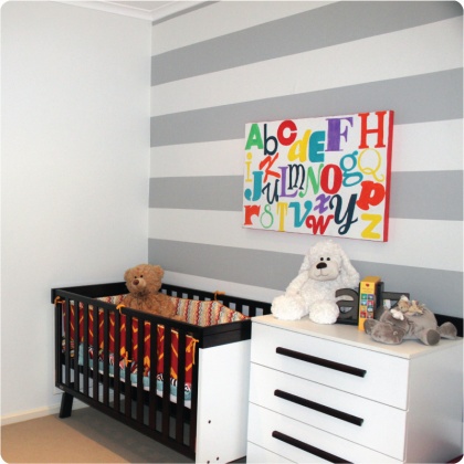 grey striped wallpaper in a nursery with wall art