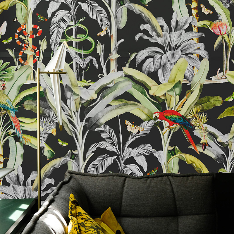 Luxe Jungle wallpaper on a wall behind a black sofa