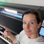 Women with her thumb up in front of a printer